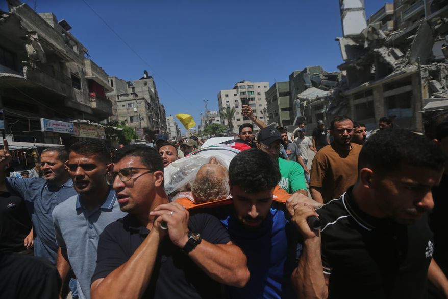 Palestinians carry the body of Mohamed al-Wahidi, director of public relations for the Egyptian Committee in Gaza, who was killed in an Israeli military strike, during his funeral in Gaza City, Wednesday, July 8, 2026. (AP Photo/Yousef Al Zanoun)