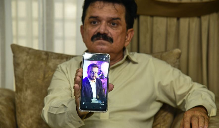 Ghulam Nabi Bahrani, father-in-law of missing cargo plane crew First Officer Faisal Jatoi, showed his picture on a mobile phone in Karachi, Pakistan, Wednesday, July 8, 2026. (AP Photo/Ali Raza)
