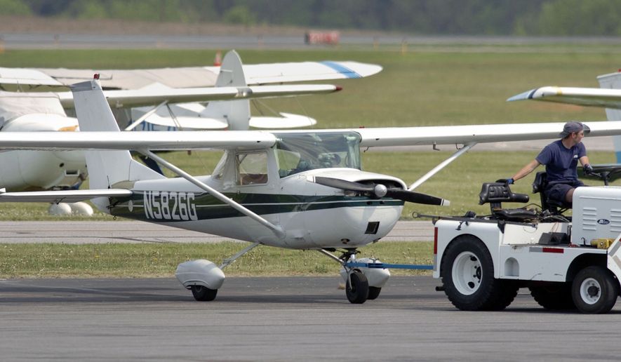 A Cessna 150 is towed to an undisclosed location at the Frederick, Md., Airport Wednesday, May 11, 2005. The plane was escorted to the airport after it entered restricted airspace and came within three miles of the White House. Two men in the aircraft, which relatives and friends said was on its way to a North Carolina air show, were taken into custody and interviewed by authorities. (AP Photo/Gail Burton)