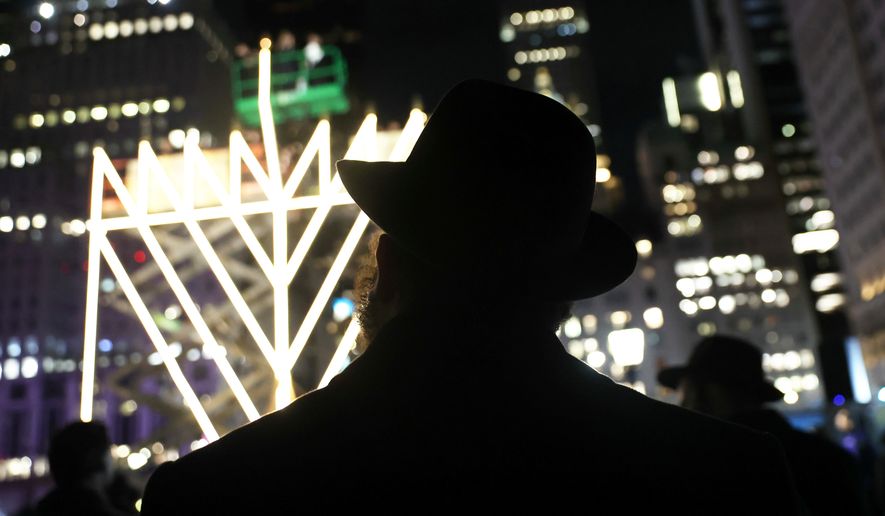 FILE - People watch the lighting of the world's largest menorah on Fifth Avenue by Central Park for the seventh night of Hanukkah, Dec. 31, 2024, in New York. (AP Photo/Heather Khalifa, File)