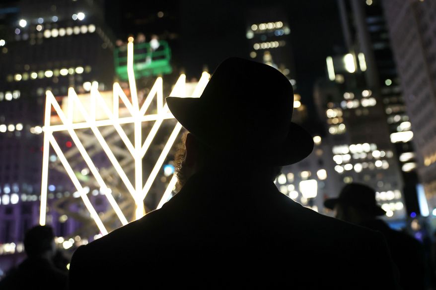 FILE - People watch the lighting of the world's largest menorah on Fifth Avenue by Central Park for the seventh night of Hanukkah, Dec. 31, 2024, in New York. (AP Photo/Heather Khalifa, File)