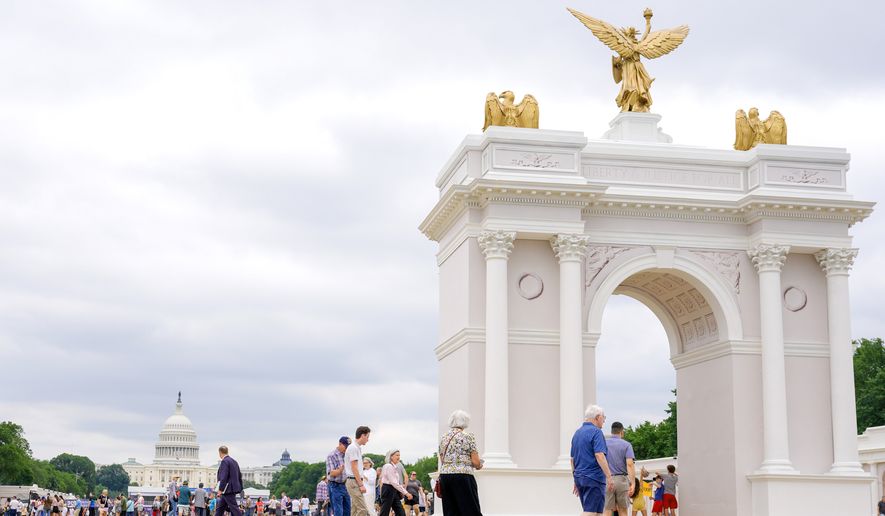Visitors walk at the Great American State Fair with the triumphal arch model and the U.S. Capitol, in the background, Wednesday, July 8, 2026, in Washington. (AP Photo/Mariam Zuhaib)