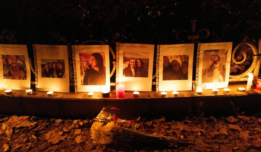 Photos showing Mackenzie Michalski, an 31-year-old American tourist who was murdered while on vacation, hang at a candlelight vigil in Budapest, Hungary, on Nov. 9, 2024. (AP Photo/Bela Szandelszky, File)