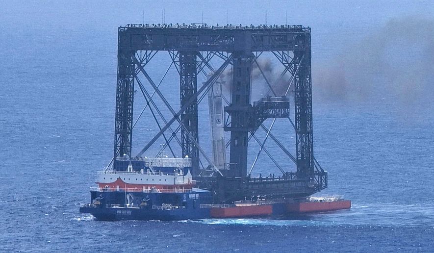In this photo released by Xinhua News Agency, a drone photo shows the successful capture of the returned first stage of Long March-10B carrier rocket on a seaborne platform via a net-capture system near Wenchang in southern China's Hainan province on Friday, July 10, 2026. (Xing Guangli/Xinhua News Agency via AP)