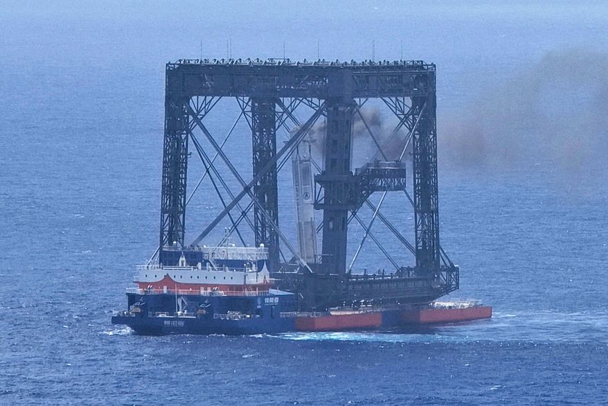 In this photo released by Xinhua News Agency, a drone photo shows the successful capture of the returned first stage of Long March-10B carrier rocket on a seaborne platform via a net-capture system near Wenchang in southern China's Hainan province on Friday, July 10, 2026. (Xing Guangli/Xinhua News Agency via AP)