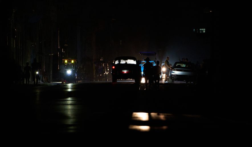 People walk along a street during a blackout in Havana, Cuba, Monday, July 6, 2026. (AP Photo/Ramon Espinosa)