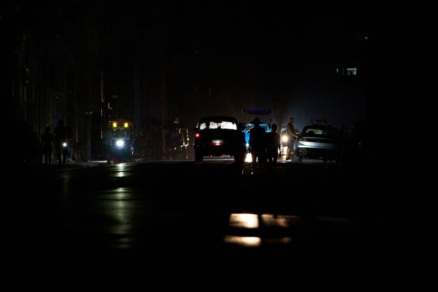 People walk along a street during a blackout in Havana, Cuba, Monday, July 6, 2026. (AP Photo/Ramon Espinosa)