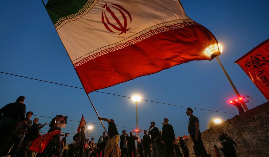 A man waves an Iranian flag during funeral ceremonies for slain Iranian Supreme Leader Ayatollah Ali Khamenei and members of his family at Imam Khomeini Mosalla Grand Mosque in Tehran, Iran, Sunday, July 5, 2026. (AP Photo/Altaf Qadri)