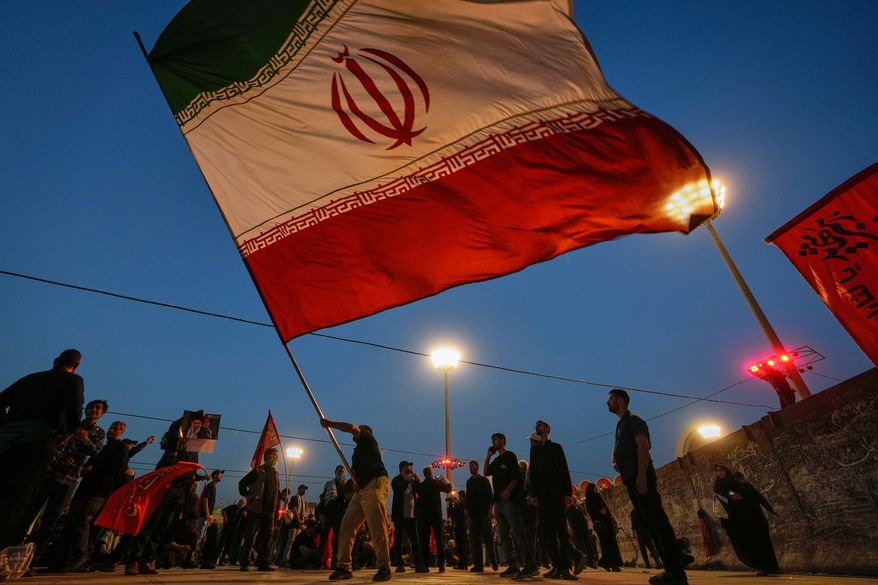 A man waves an Iranian flag during funeral ceremonies for slain Iranian Supreme Leader Ayatollah Ali Khamenei and members of his family at Imam Khomeini Mosalla Grand Mosque in Tehran, Iran, Sunday, July 5, 2026. (AP Photo/Altaf Qadri)