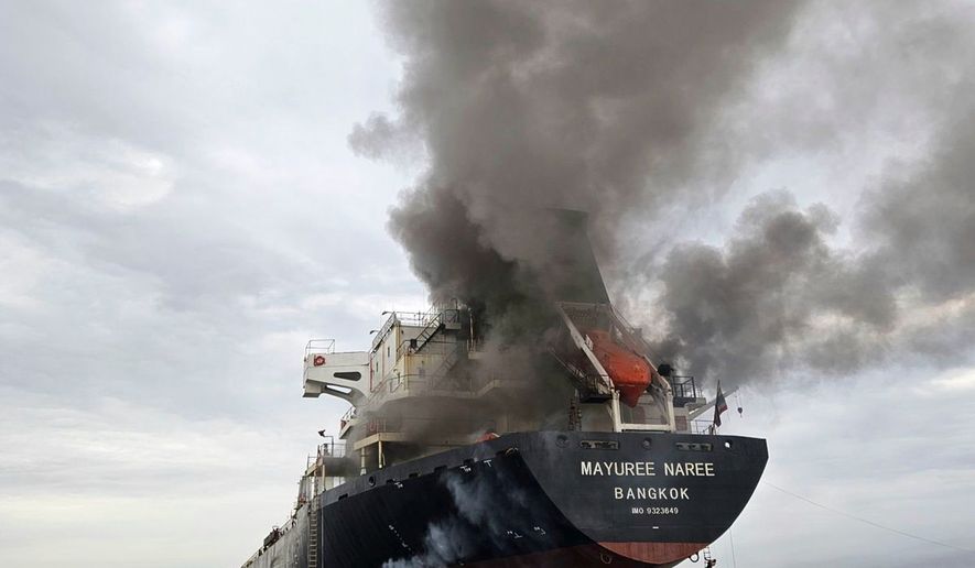 Smoke billows from the Mayuree Naree, a Thailand-flagged bulk carrier, after it was hit by a projectile in the Strait of Hormuz, north of Oman, on March 11, 2026. (Panithi Tumkaew via AP)