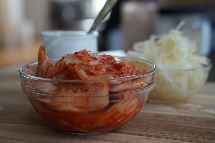 Kimchi, sauerkraut and yogurt are displayed on a kitchen table in New York on July 10, 2026. (AP Photo/Mary Conlon)
