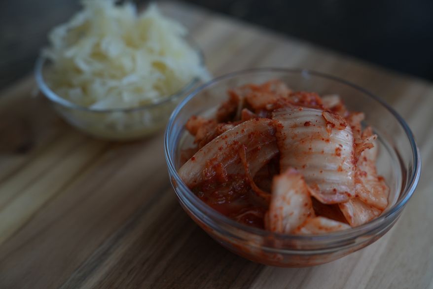 Kimchi and sauerkraut are displayed on a kitchen table in New York on July 10, 2026. (AP Photo/Mary Conlon)