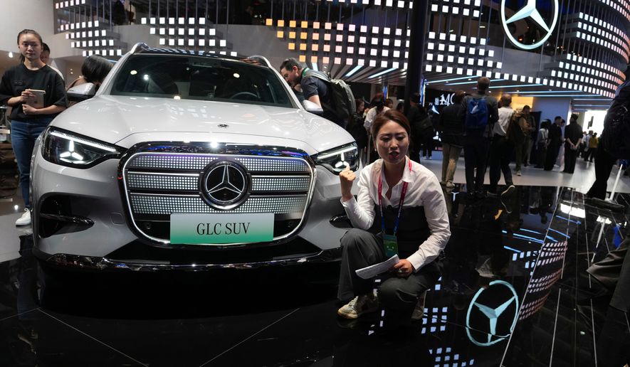 A vlogger promotes the GLC SUV at the Mercedes-Benz booth during Auto China 2026 in Beijing, on April 24, 2026. Major German carmakers saw sharp quarterly sales declines in China, as domestic demand weakened and competition heats up in the world’s biggest auto market. (AP Photo/Ng Han Guan)