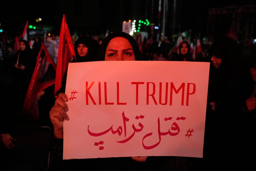 A pro-government demonstrator holds an anti-Trump placard in a gathering commemorating the late Iranian Supreme Leader Ayatollah Ali Khamenei at a square in Tehran, Saturday, July 11, 2026. (AP Photo/Vahid Salemi)