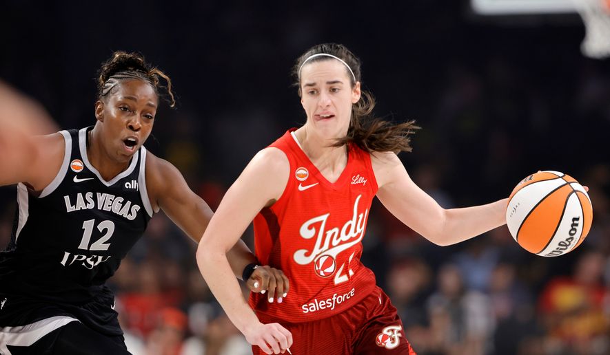 Indiana Fever guard Caitlin Clark (22) drives against Las Vegas Aces guard Chelsea Gray (12) during the first half of a WNBA basketball game Sunday, July 12, 2026, in Las Vegas. (Steve Marcus/Las Vegas Sun via AP)