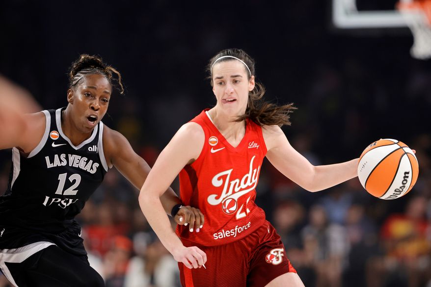 Indiana Fever guard Caitlin Clark (22) drives against Las Vegas Aces guard Chelsea Gray (12) during the first half of a WNBA basketball game Sunday, July 12, 2026, in Las Vegas. (Steve Marcus/Las Vegas Sun via AP)