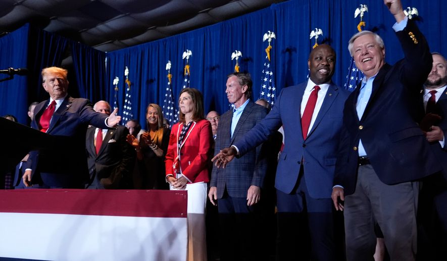 FILE - Republican presidential candidate former President Donald Trump speaks as Sen. Tim Scott, R-S.C., and Sen. Lindsey Graham, R-S.C., listen, at a primary election night party at the South Carolina State Fairgrounds in Columbia, S.C., Feb. 24, 2024. (AP Photo/Andrew Harnik, File)