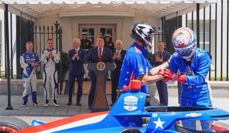 IndyCar Series driver David Malukas, right, exits a race car following a demonstration as Felix Rosenqvist, the 2026 Indy 500 winner, from left, Alex Palou, the reigning IndyCar champion, Bud Denker, Freedom 250 Grand Prix chair and Penske Corp. president, President Donald Trump, Roger Penske, chairperson and founder of Penske Corp., and Fox Sports CEO Eric Shanks watch on West Executive Drive at the White House during a showcase for the upcoming Freedom 250 Grand Prix auto race, Monday, July 13, 2026, in Washington. (AP Photo/Alex Brandon)