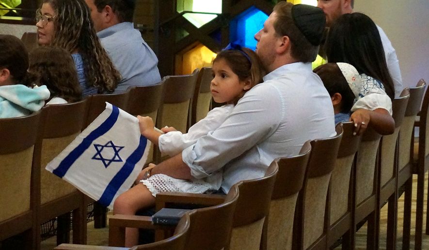 A family with Israel flags attends Shabbat services at Temple Beth Sholom in Miami Beach, Fla., Oct. 13, 2023. (AP Photo/Giovanna Dell'Orto, File)