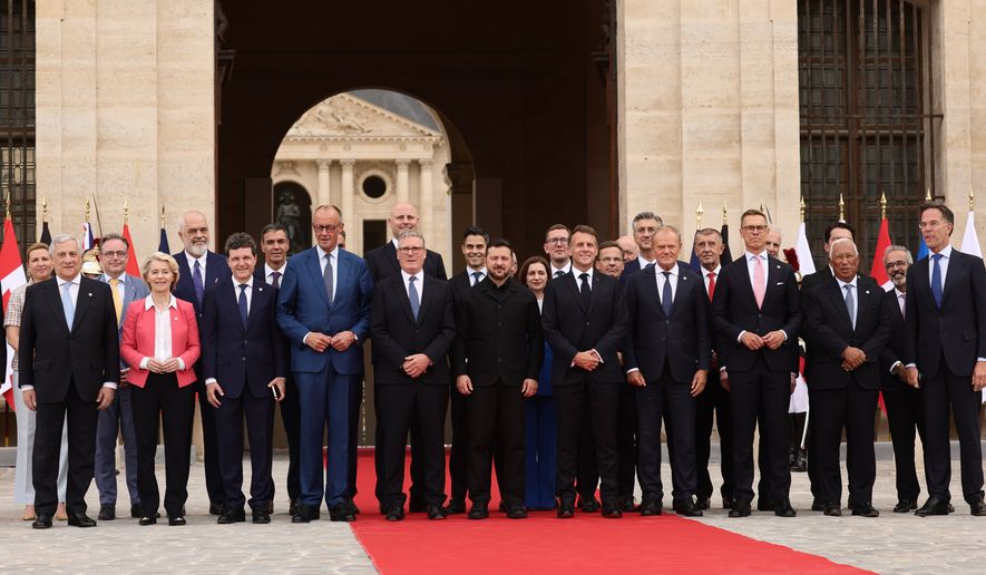 French President Emmanuel Macron and Ukrainian President Volodymyr Zelensky pose for a group photo with heads of states and governments ahead of the Coalition of the Willing summit on security guarantees for Ukraine at the Hotel des Invalides in Paris, France, Monday, July 13, 2026. (Teresa Suarez/POOL photo via AP)