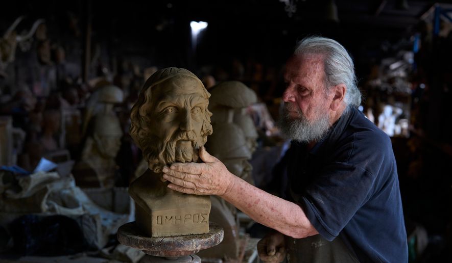 Sculptor and ceramicist Haralambos Goumas works on a terracotta bust of the ancient Greek poet Homer, the author of the Iliad and the Odyssey, at his workshop in the Athens suburb of Aigaleo, Wednesday, May 27, 2026. (AP Photo/Petros Giannakouris)