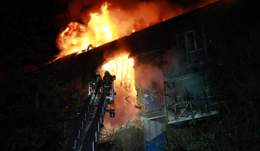 Rescue workers try to put out a fire of a residential building burning after a Russian drone attack on Zaporizhzhia, Ukraine, late Sunday, July 12, 2026. (AP Photo/Kateryna Klochko)