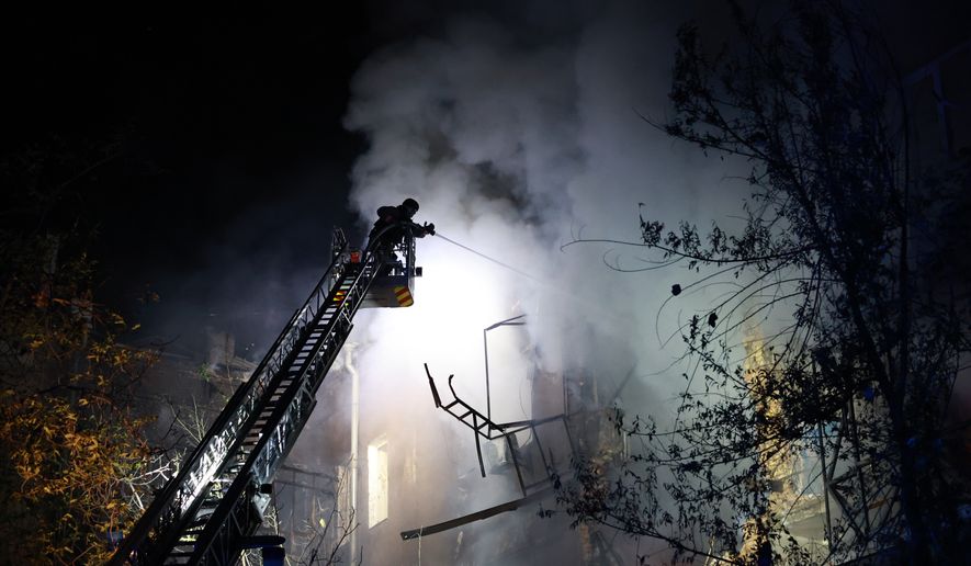 Rescue workers try to put out a fire of a residential building burning after a Russian drone attack on Zaporizhzhia, Ukraine, late Sunday, July 12, 2026. (AP Photo/Kateryna Klochko)