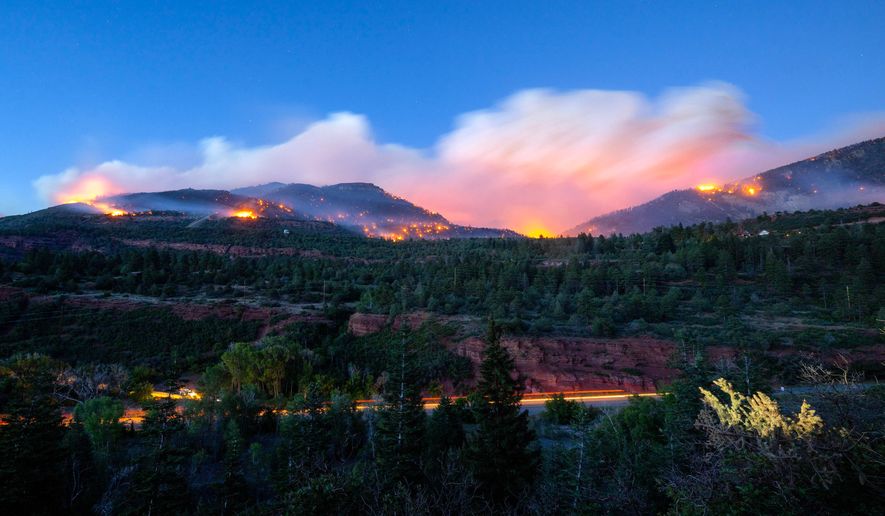 Firefighters drive along Highway 550 as they try to access the Gold Mountain Fire on the town line of Ouray and Ridgeway, Colo., on Sunday, June 28, 2026. (Michael Seamans/The Gazette via AP)