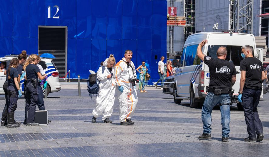 Emergency and forensic workers on site during a fire at a building complex in the center of Brussels, Tuesday, July 14, 2026. (AP Photo/Marius Burgelman)