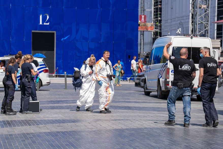 Emergency and forensic workers on site during a fire at a building complex in the center of Brussels, Tuesday, July 14, 2026. (AP Photo/Marius Burgelman)