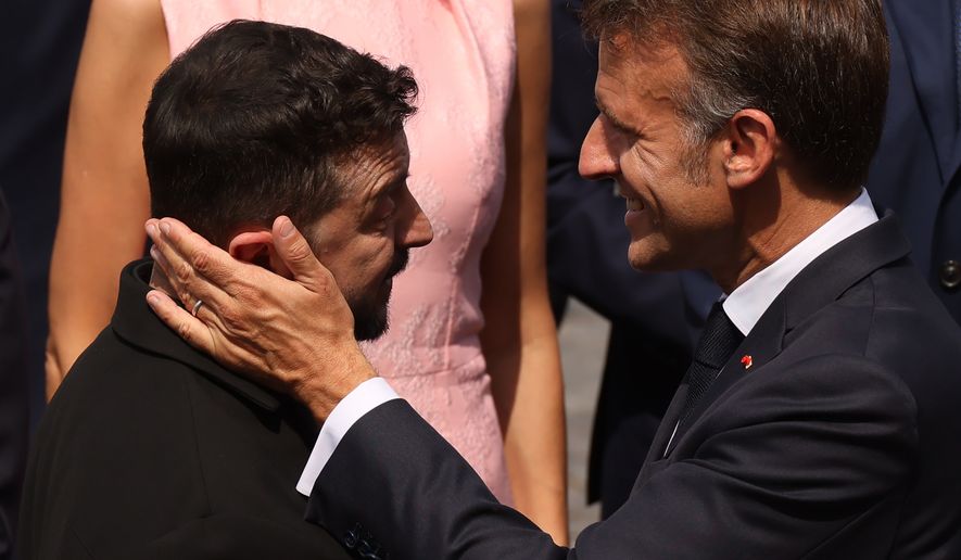 French President Emmanuel Macron, right, speaks with Ukraine's President Volodymyr Zelensky after the Bastille Day military parade on the Champs-Elysees avenue, in Paris, Tuesday, July 14, 2026. (AP Photo/Thomas Padilla)