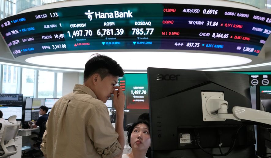 Currency traders work at the foreign exchange dealing room of the Hana Bank headquarters in Seoul, South Korea, Tuesday, July 14, 2026. (AP Photo/Ahn Young-joon)