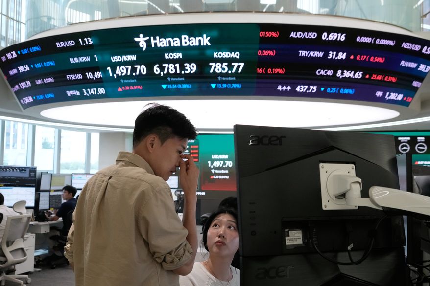 Currency traders work at the foreign exchange dealing room of the Hana Bank headquarters in Seoul, South Korea, Tuesday, July 14, 2026. (AP Photo/Ahn Young-joon)