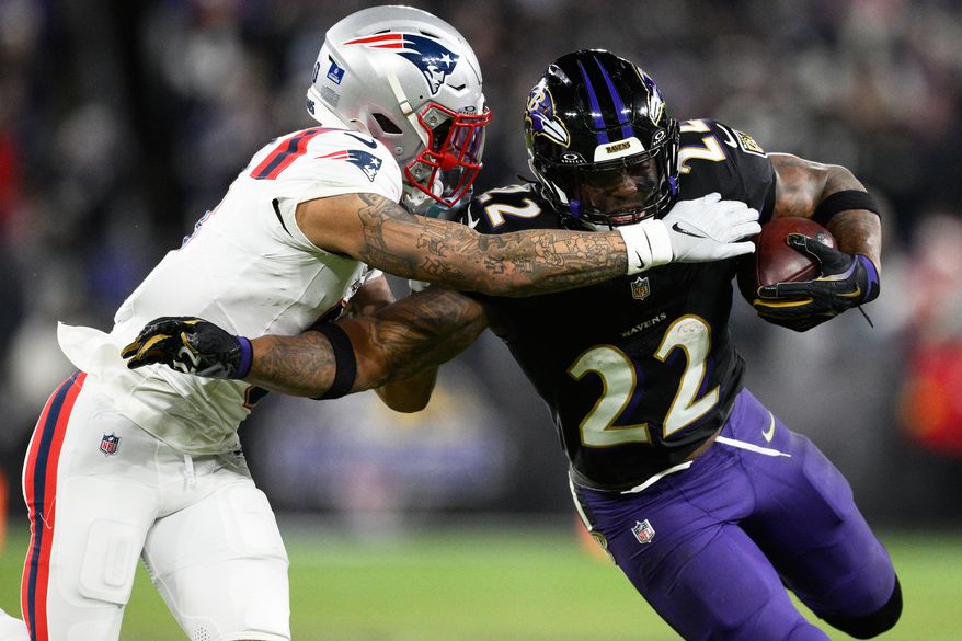 Baltimore Ravens running back Derrick Henry (22) runs against New England Patriots cornerback Christian Gonzalez during the second half of an NFL football game, Dec. 21, 2025, in Baltimore. (AP Photo/Nick Wass, File)