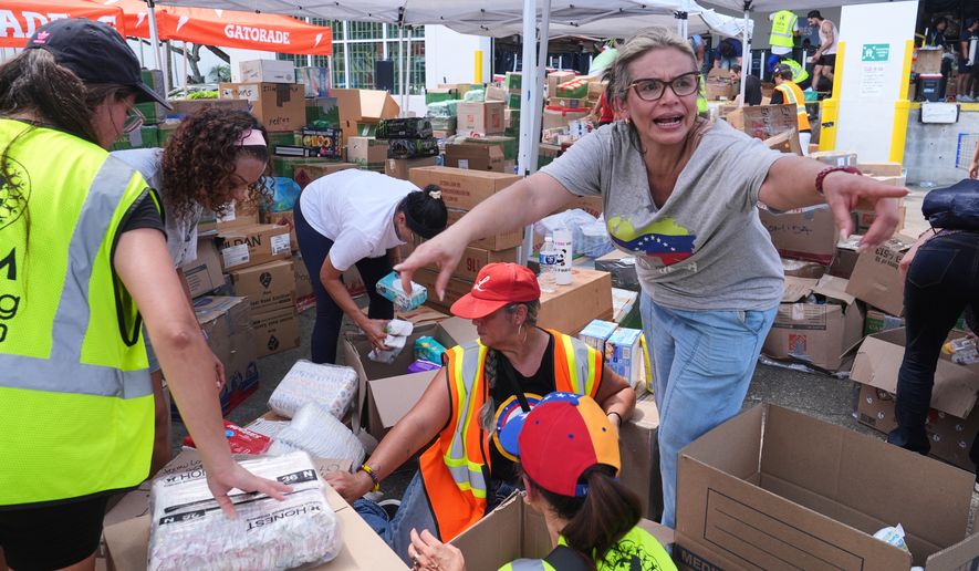 Lisa Galindez calls on other volunteers to help pack baby items at the Global Empowerment Mission Venezuela relief donation site Tuesday, June 30, 2026, in Doral, Fla. (AP Photo/Marta Lavandier)