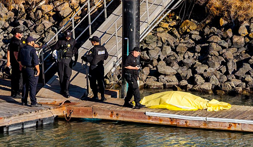 First responders stand near a body after a boat accident near Alcatraz Island off San Francisco, Tuesday, July 14, 2026. (AP Photo/Noah Berger)