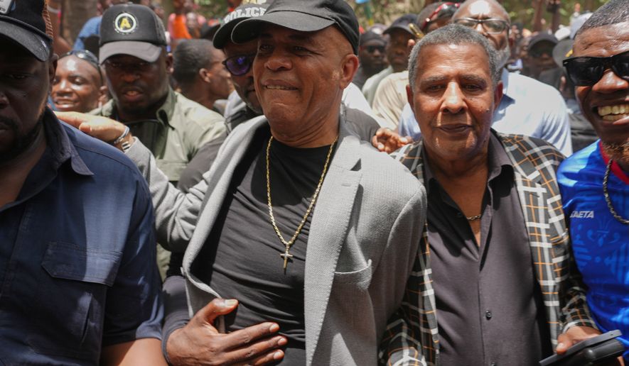 Former Haitian President Michel Martelly, center, who lives in the U.S., walks with supporters who came to welcome him home in Port-au-Prince, Haiti, Wednesday, July 15, 2026. (AP Photo/Odelyn Joseph)