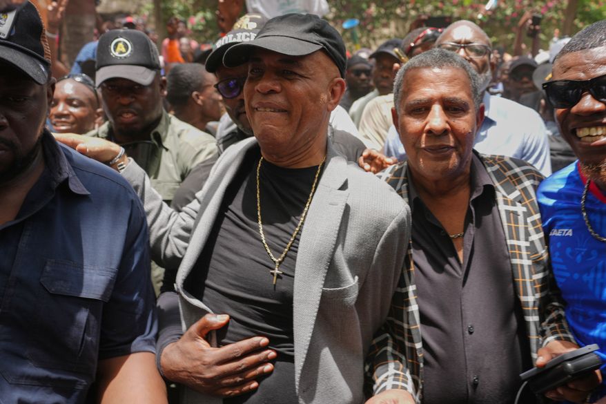 Former Haitian President Michel Martelly, center, who lives in the U.S., walks with supporters who came to welcome him home in Port-au-Prince, Haiti, Wednesday, July 15, 2026. (AP Photo/Odelyn Joseph)