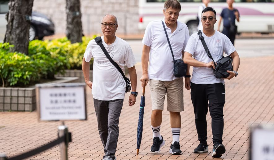 Yip Ka Kui, left, a family member of a victim of the last year's deadly fire, arrives for the independent committee hearing in Hong Kong, Wednesday, July 15, 2026. (AP Photo/Chan Long Hei)