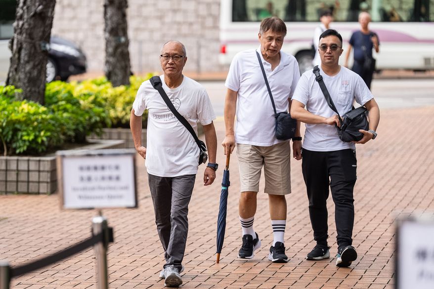 Yip Ka Kui, left, a family member of a victim of the last year's deadly fire, arrives for the independent committee hearing in Hong Kong, Wednesday, July 15, 2026. (AP Photo/Chan Long Hei)