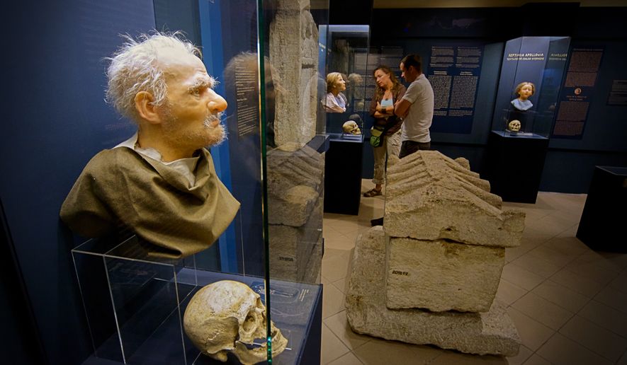 Visitors look at Roman-era skulls and their facial reconstructions in the Aquincum Museum's exhibition titled "Once we were like you" which showcases characters and the fictional life stories of those who once lived in the bustling Roman settlement of Aquincum, in Budapest, Hungary, Tuesday, July 7, 2026. (AP Photo/Bela Szandelszky)