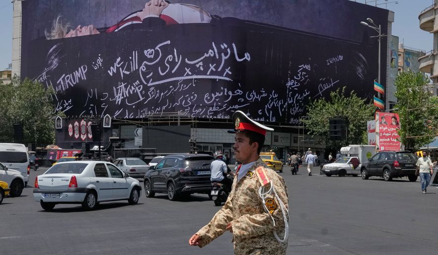 An army cadet walks past a billboard bearing anti-Trump messages, including the phrase "We Kill Trump," at Islamic Revolution Square in downtown Tehran, Iran, Wednesday, July 15, 2026. (AP Photo/Vahid Salemi)
