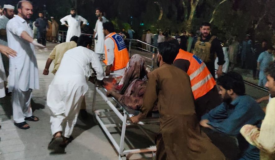 Rescue workers and volunteers transport an injured victim of a suicide bomber upon arrival at a hospital in Bannu, in northwest, Pakistan, Wednesday, July 15, 2026. (AP Photo/Aamad Khattak)