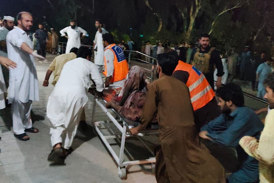 Rescue workers and volunteers transport an injured victim of a suicide bomber upon arrival at a hospital in Bannu, in northwest, Pakistan, Wednesday, July 15, 2026. (AP Photo/Aamad Khattak)