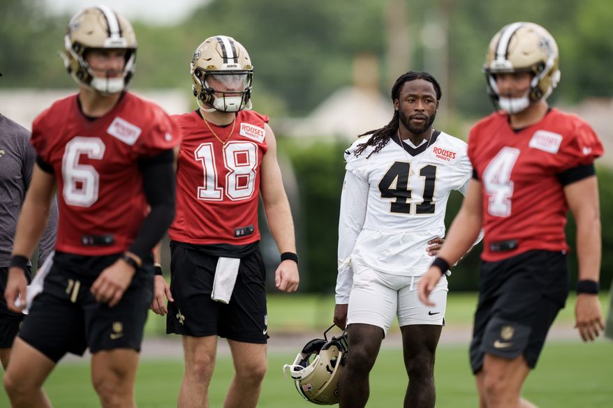 New Orleans Saints running back Alvin Kamara (41), second right, watches practice with quarterback Hunter Dekkers (18), second left, during the NFL football team's practice in Metairie, La., Wednesday, June 17, 2026. (AP Photo/Matthew Hinton)