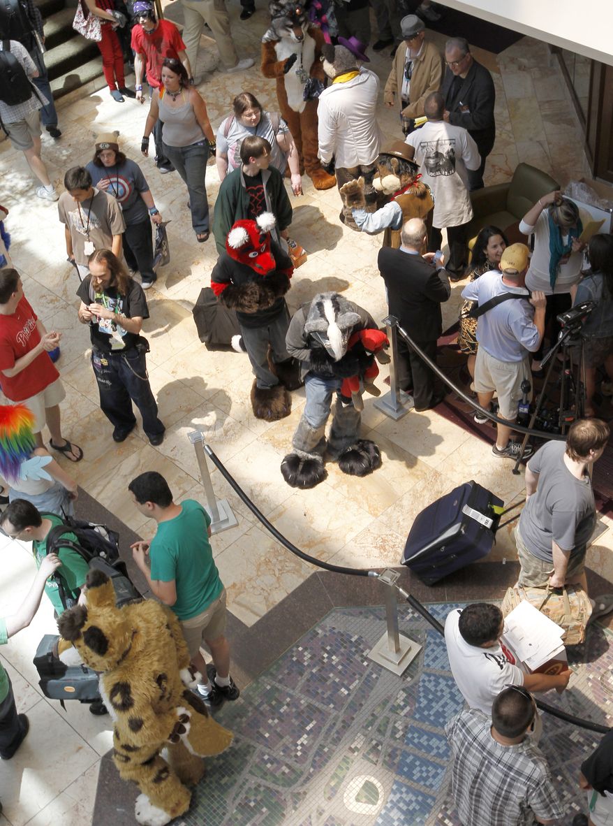 In this photo made on Thursday, June 14, 2012, people attending Anthrocon, some in animal costumes, greet and mingle in the lobby of the Westin Convention Center hotel in Pittsburgh. Anthrocon is the world's largest convention for people who dress and assume the rolls of fictional animal characters. (AP Photo/Keith Srakocic)