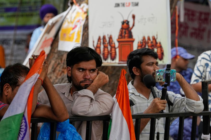 Supporters listen to a speaker during a protest by the Cockroach Janta Party demanding the resignation of Education Minister Dharmendra Pradhan over alleged examination irregularities and repeated paper leaks, in New Delhi, India, on July 10, 2026. (AP Photo/Manish Swarup)