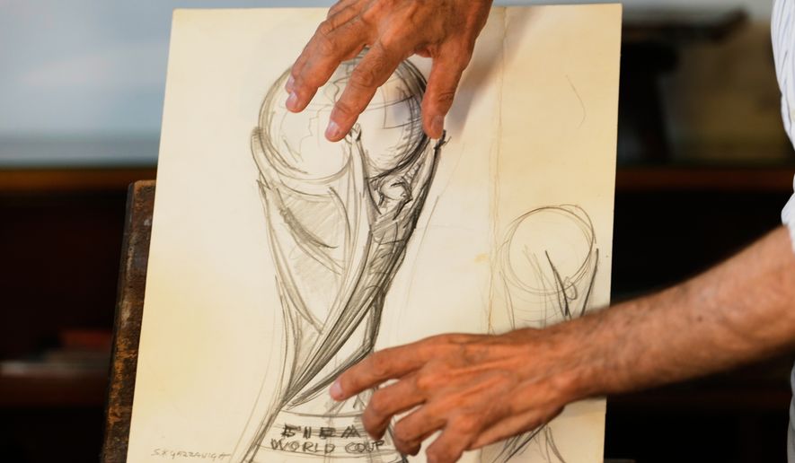 Giorgio Gazzaniga, son of the late sculptor Silvio Gazzaniga, gestures as he speak to the Associated Press explaining the original drawing of World Cup trophy at a warehouse in Pioltello, Saturday, July 11, 2026. (AP Photo/Luca Bruno)