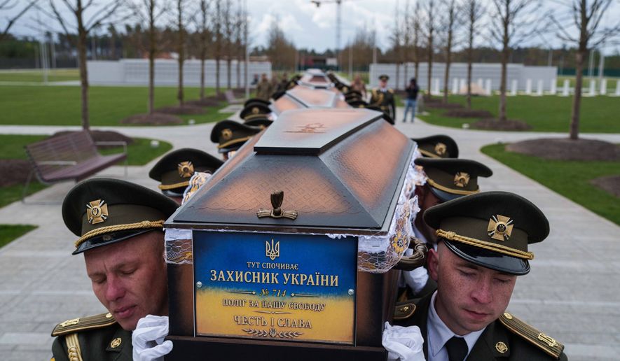 FILE - An honor guard carries the coffins of unidentified Ukrainian soldiers killed in battle during the Russian-Ukrainian war at a funeral ceremony at a military cemetery near Kyiv, Ukraine, April 30, 2026. (AP Photo/Evgeniy Maloletka, File)