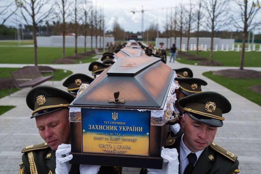 FILE - An honor guard carries the coffins of unidentified Ukrainian soldiers killed in battle during the Russian-Ukrainian war at a funeral ceremony at a military cemetery near Kyiv, Ukraine, April 30, 2026. (AP Photo/Evgeniy Maloletka, File)